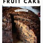 A round Rum Fruit Cake with a two slices cut and pulled out to show the inside of the cake.