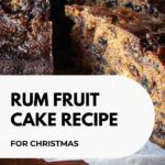 A round Rum Fruit Cake with a two slices cut and pulled out to show the inside of the cake.