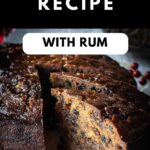A round Rum Fruit Cake with a two slices cut and pulled out to show the inside of the cake.