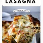 A slice of vegetable lasagna with white sauce being lifted out of a baking dish.