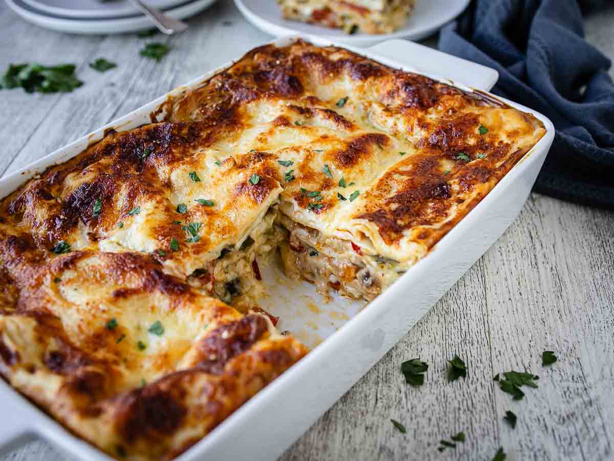 Lasagna in a rectangle dish with a piece cut out.