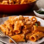 Creamy sausage pasta on a plate with a fork.