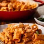 Creamy sausage pasta on a plate with a fork.