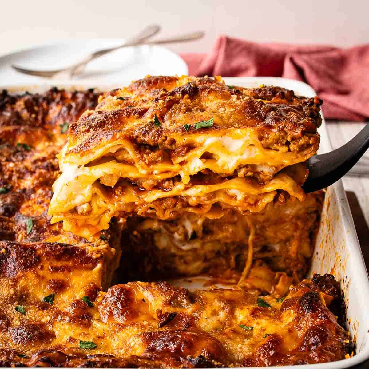 Baked Lasagna al Forno with a piece cut and being lifted out.