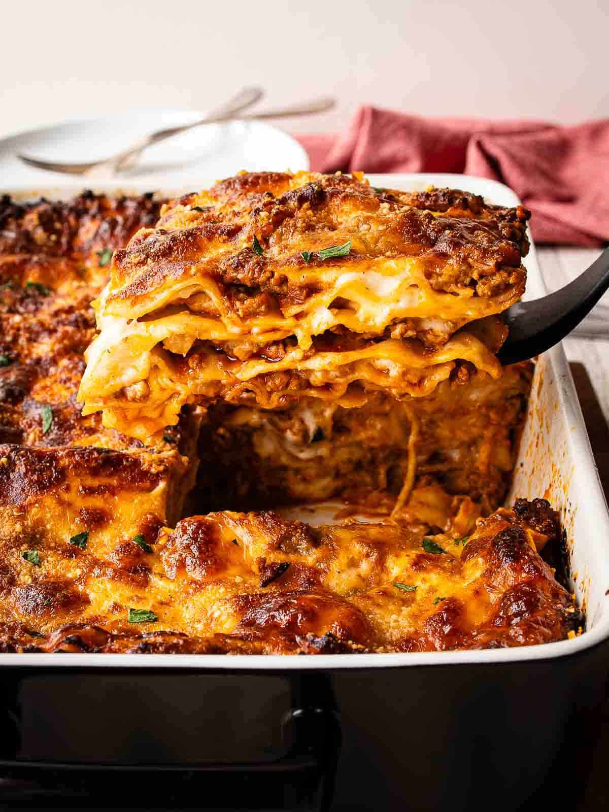 Baked Lasagna al Forno with a piece cut and being lifted out.