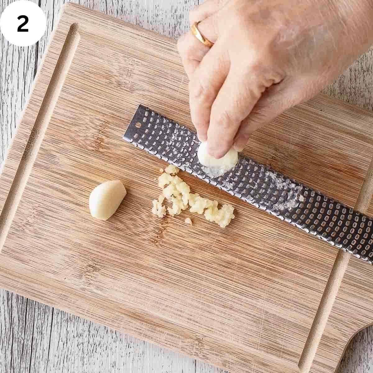 Mincing fresh garlic on a microplane grater.