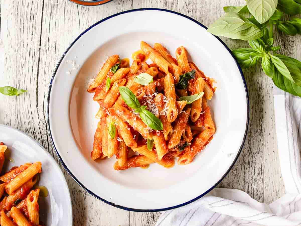 Penne pasta in a tomato sauce served in a bowl viewed from above.