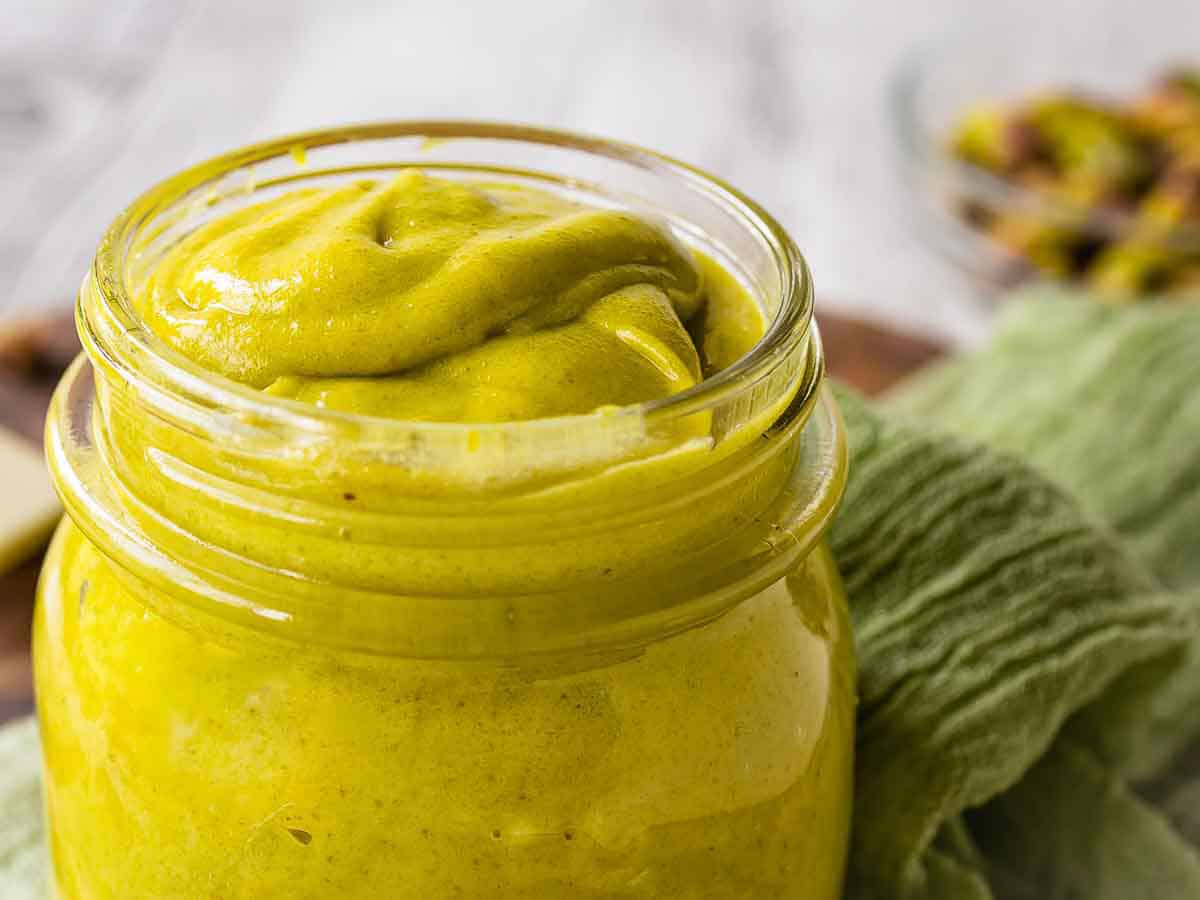 Smooth creamy paste made of pistachios in a glass jar.