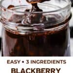 Blackberry compote being spooned into a glass jar.
