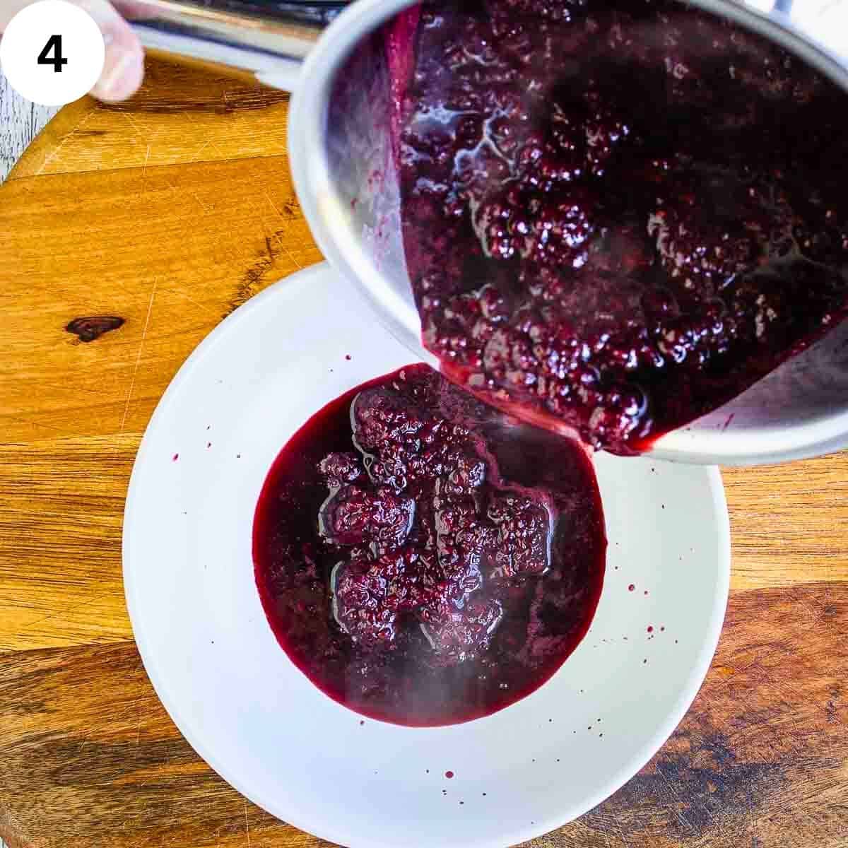 Berry compote being poured into a shallow bowl.