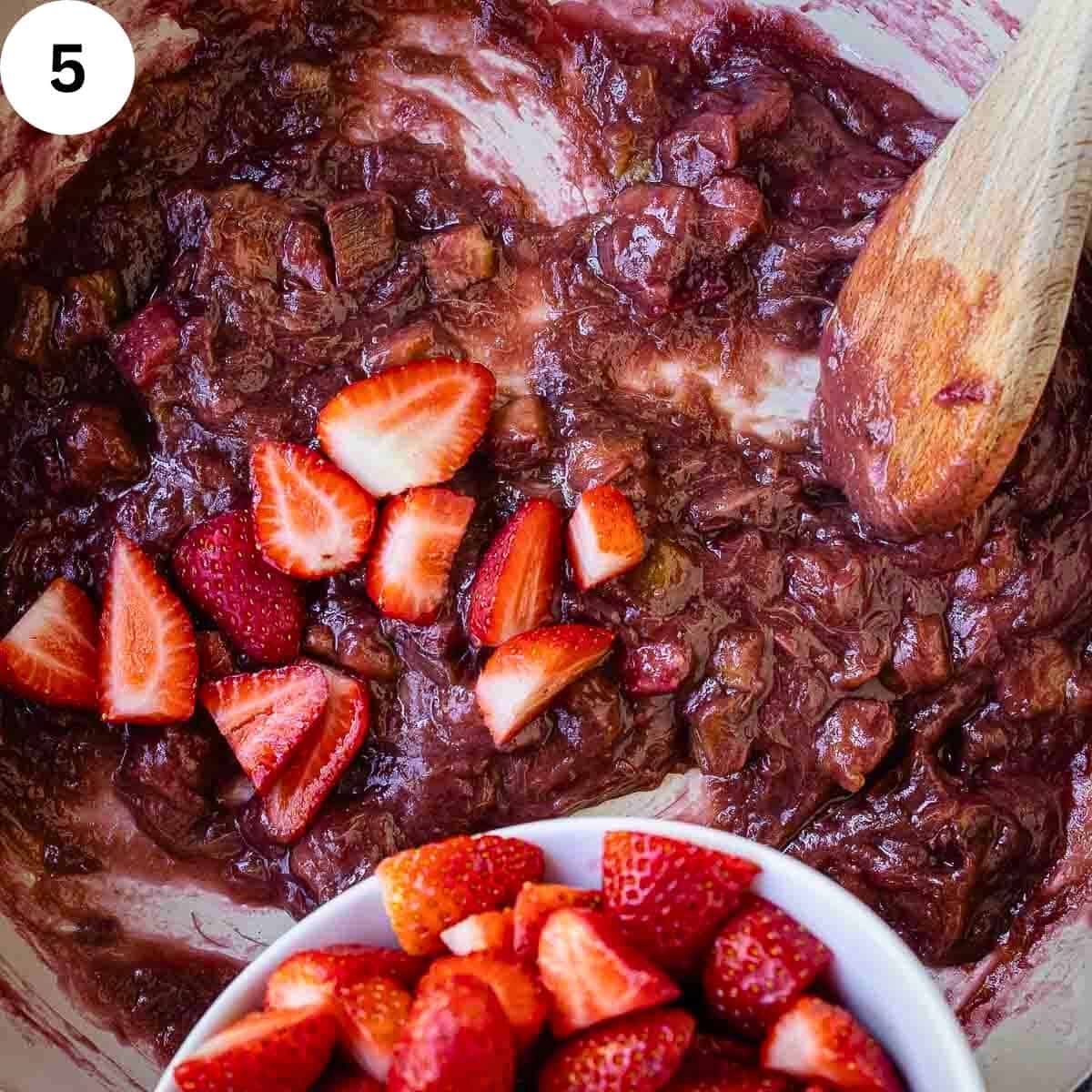 Adding strawberries into cooked rhubarb.