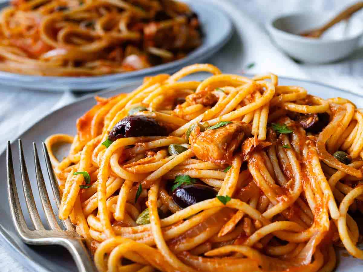 Close up of a plate of spaghetti with a tuna and tomato sauce.