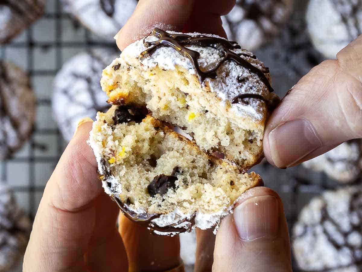 Hands holding two halves of a cookie.
