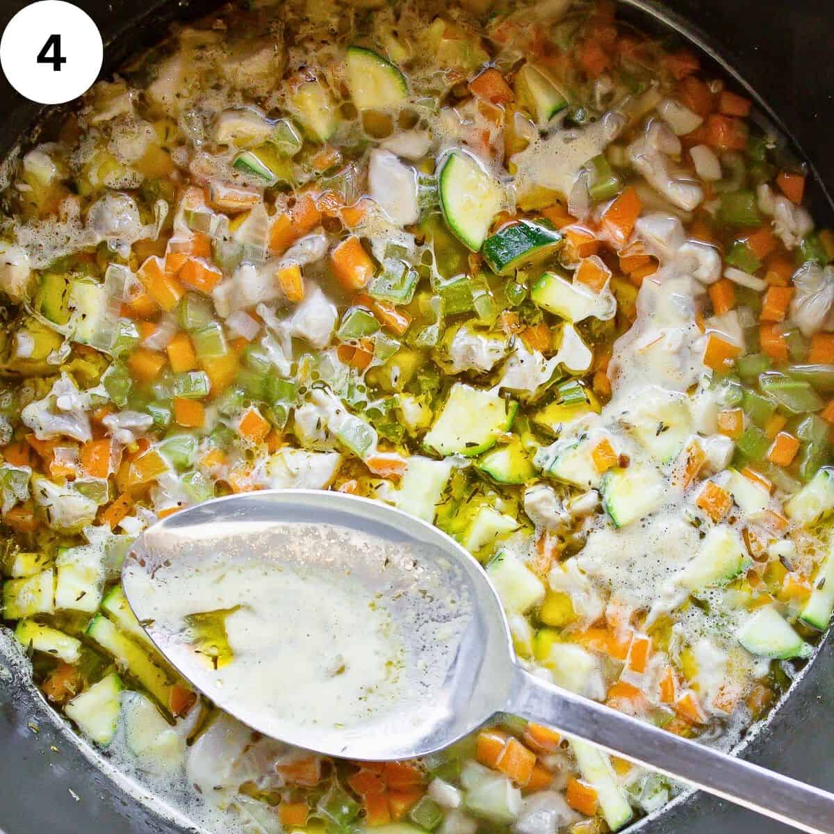 Skimming scum off soup with large spoon.