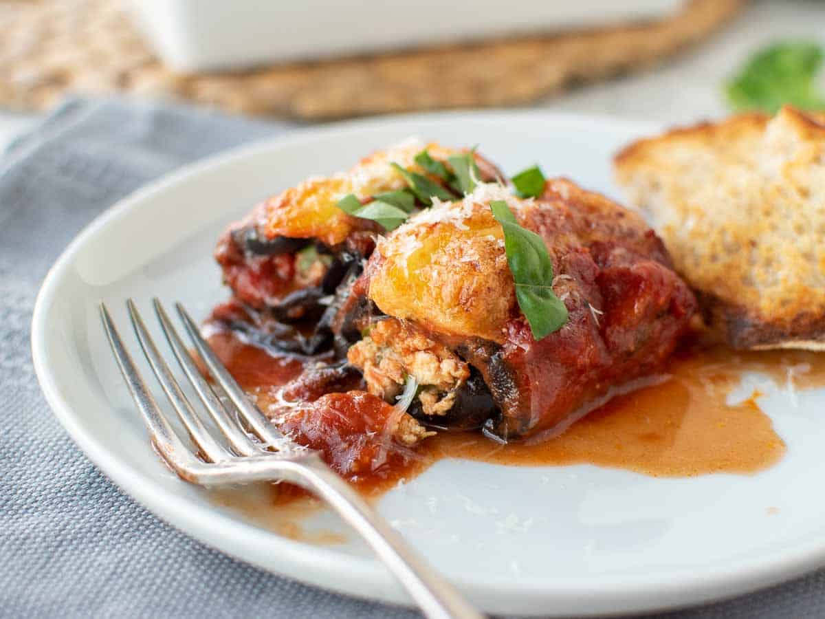 Eggplant Rollatini rolled and filled and topped with tomato sauce and cheese.