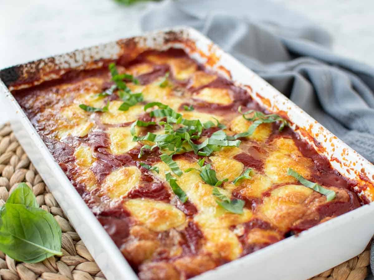 Baked tomato and cheese in a white baking dish.
