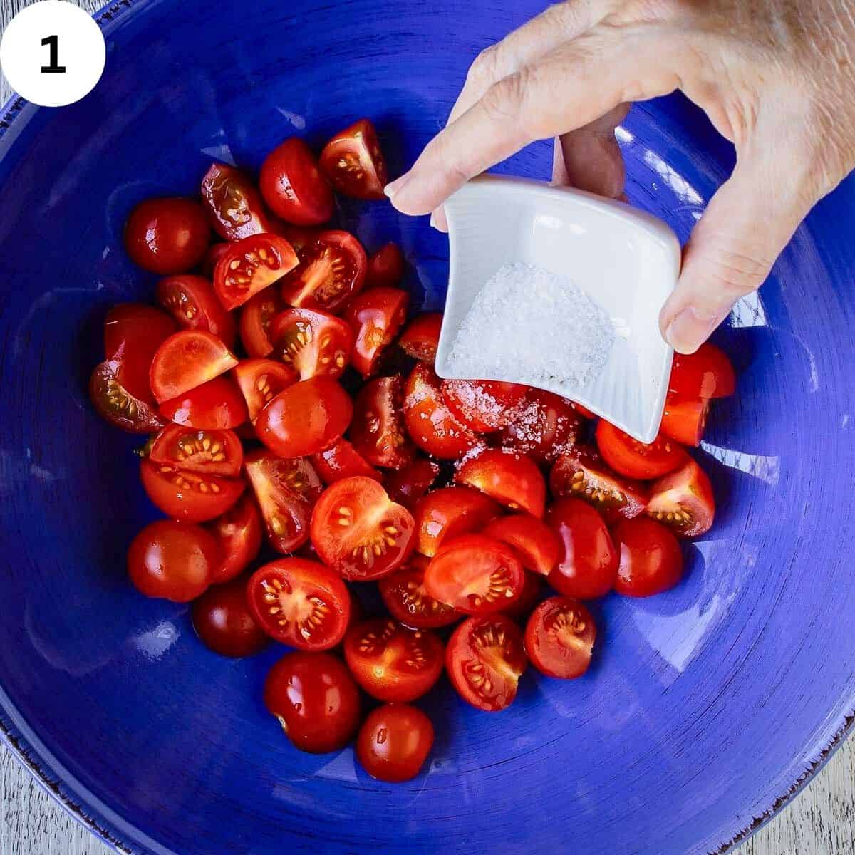 Adding salt to chopped tomatoes.
