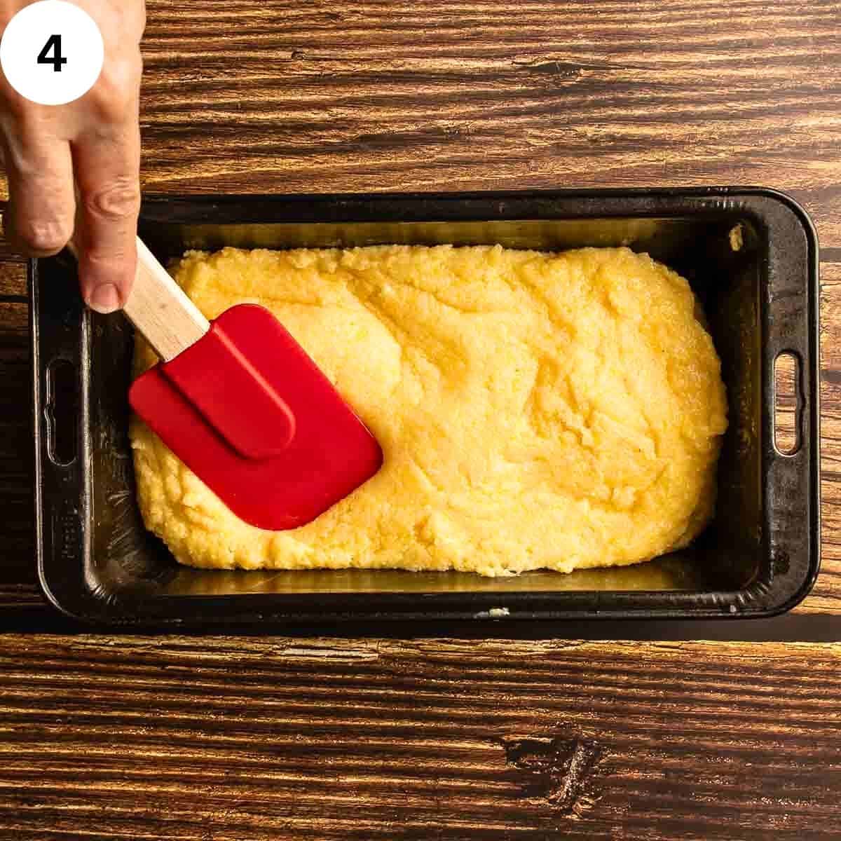 Spreading polenta into a loaf pan.