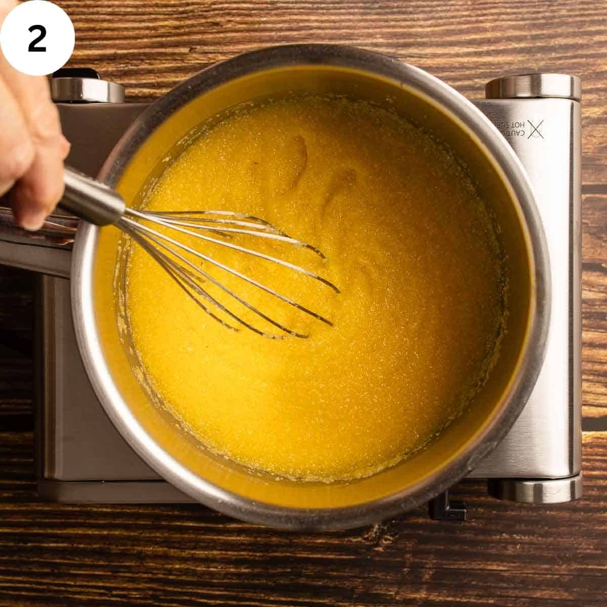 Whisking polenta in a saucepan.