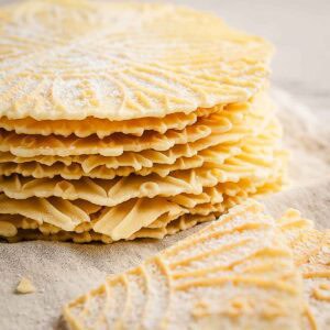 A stack of pizzelle cookies made from an anise pizzelle recipe.