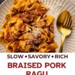 Overhead view of pappardelle pasta with pork ragu sauce on a plate with fork and spoon.