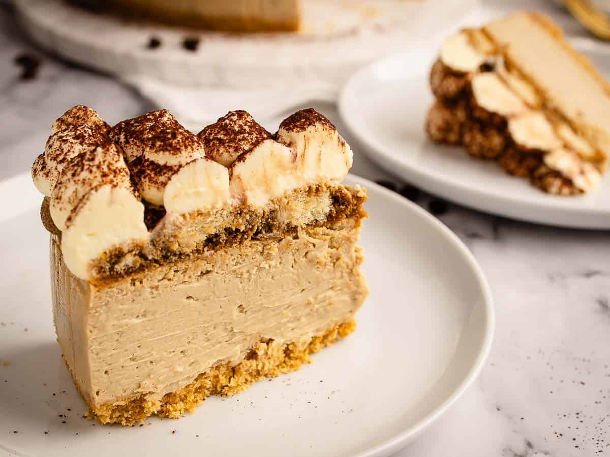 A slice of cheesecake topped with pipe cream topping on a plate.