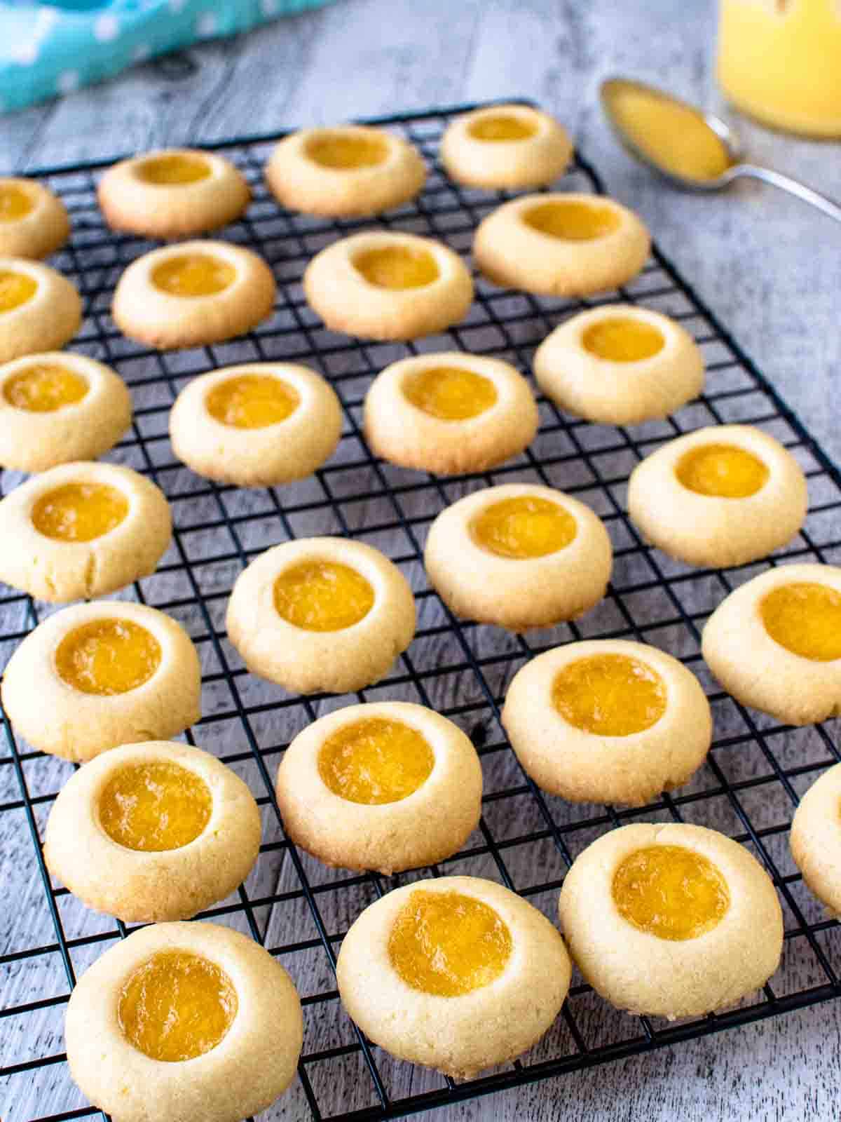 Rows of baked lemon curd cookies on a black wire rack.