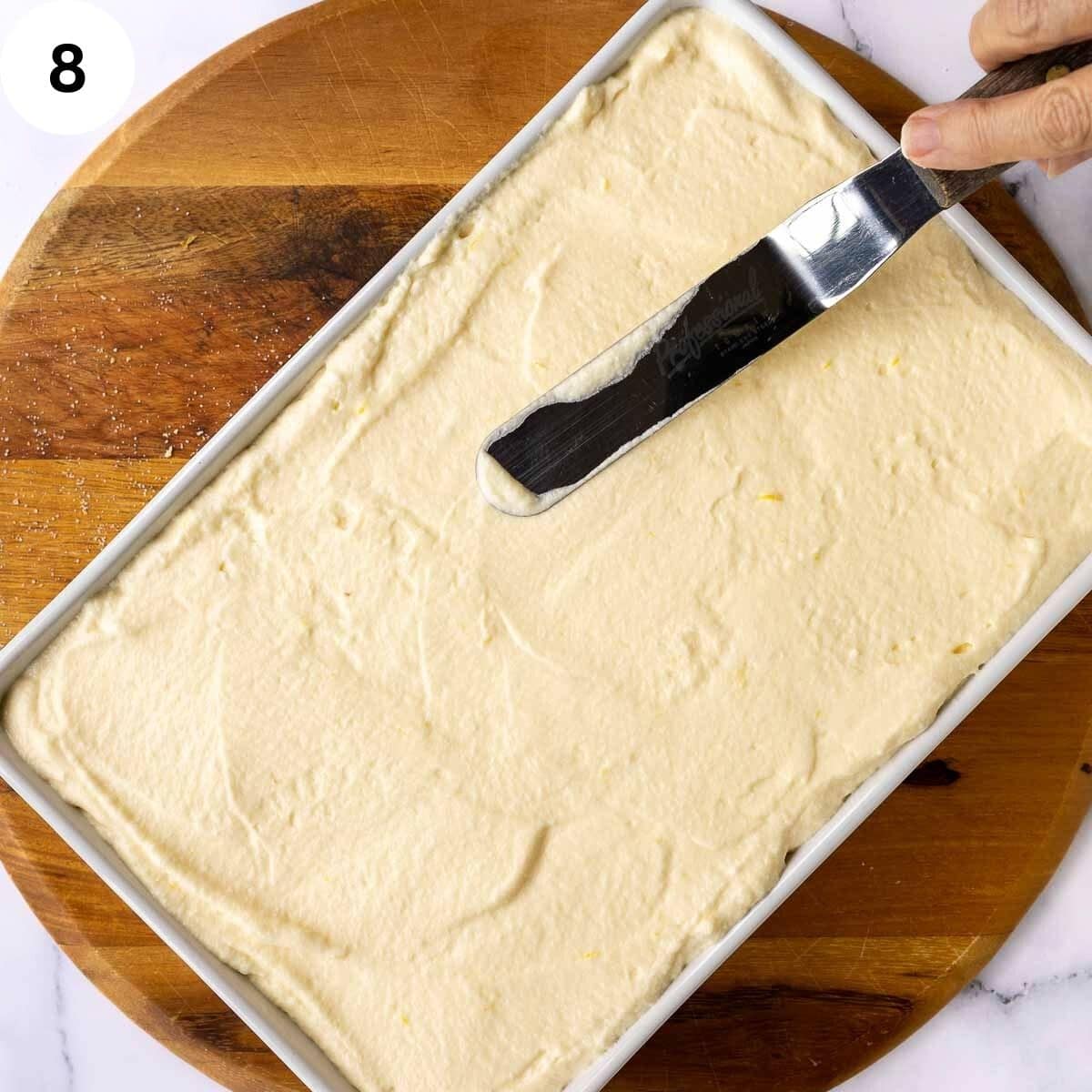 Smoothing the top of a tiramisu dessert.