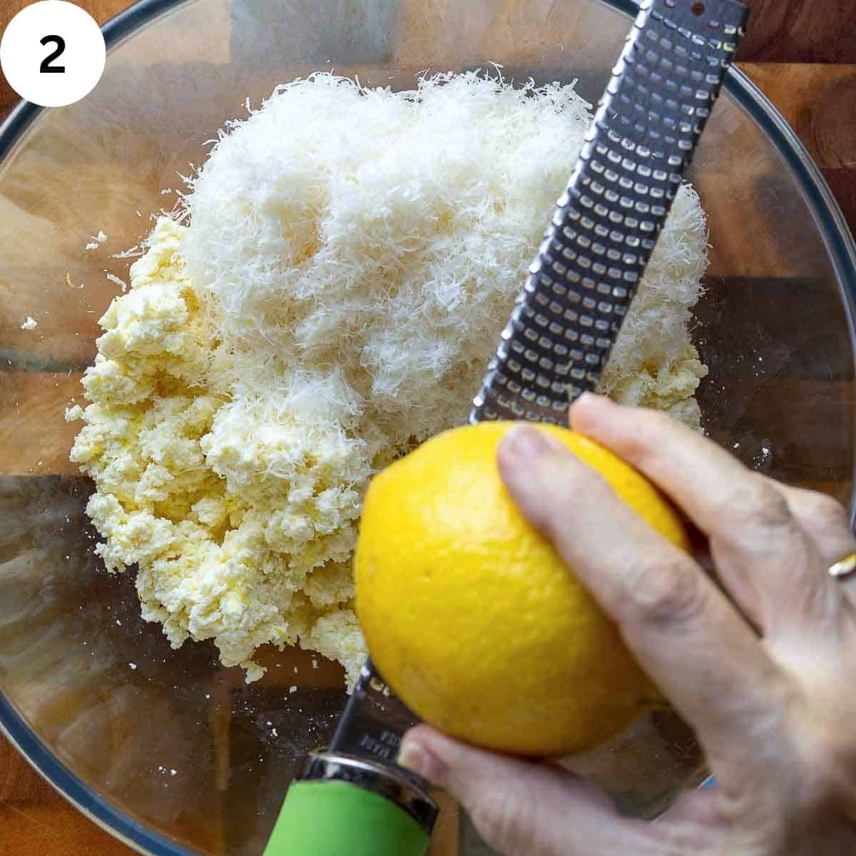 Grating the zest of lemon over a bowl of ricotta and Parmesan cheese.