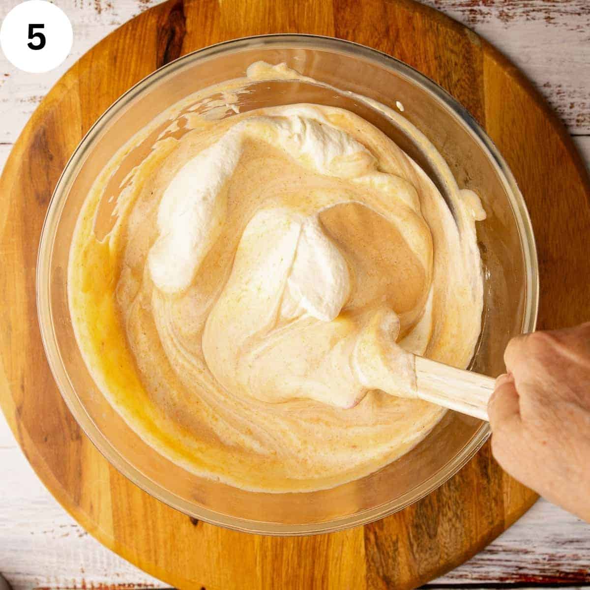 Folding peach puree into whipped cream.