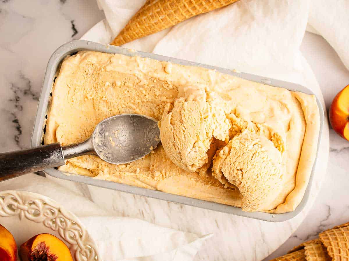 Overhead view of ice cream in a loaf pan with some scooped into balls.