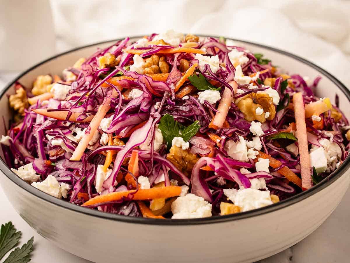 Close up of a salad of red cabbage, carrots and apple.