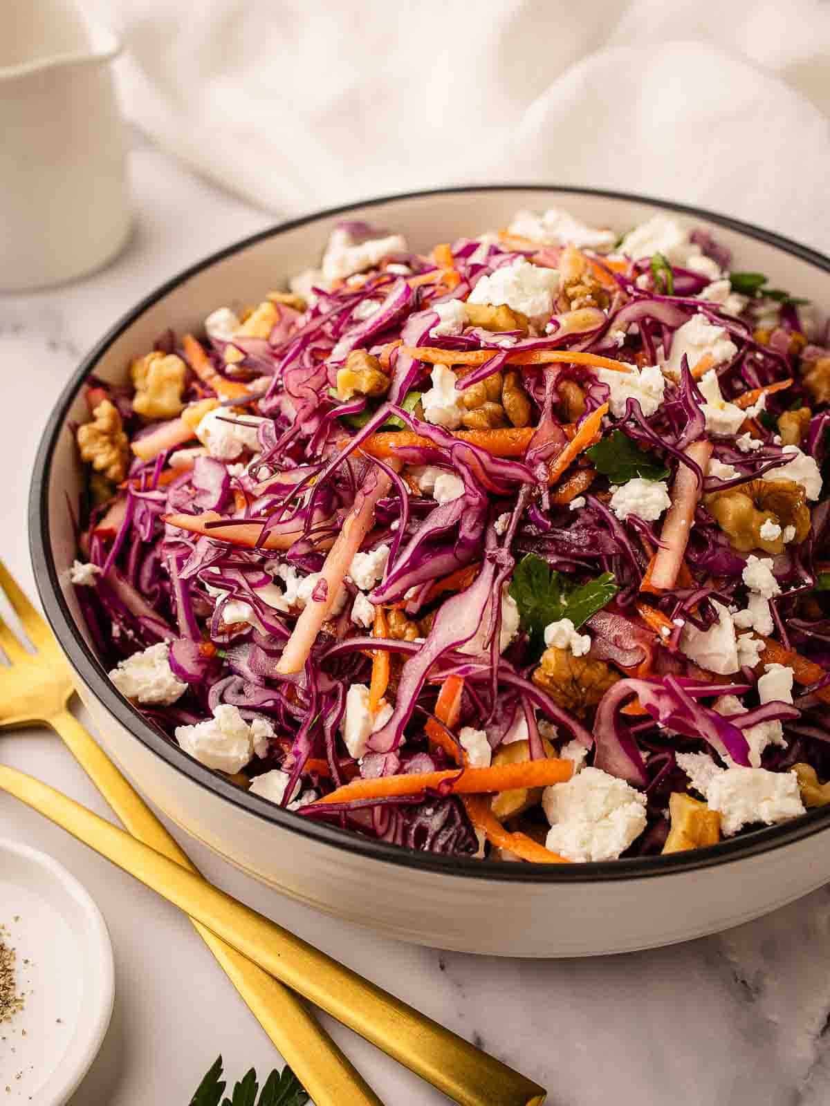 Red Cabbage Salad with red cabbage, grated carrot topped with feta in a round serving bowl.