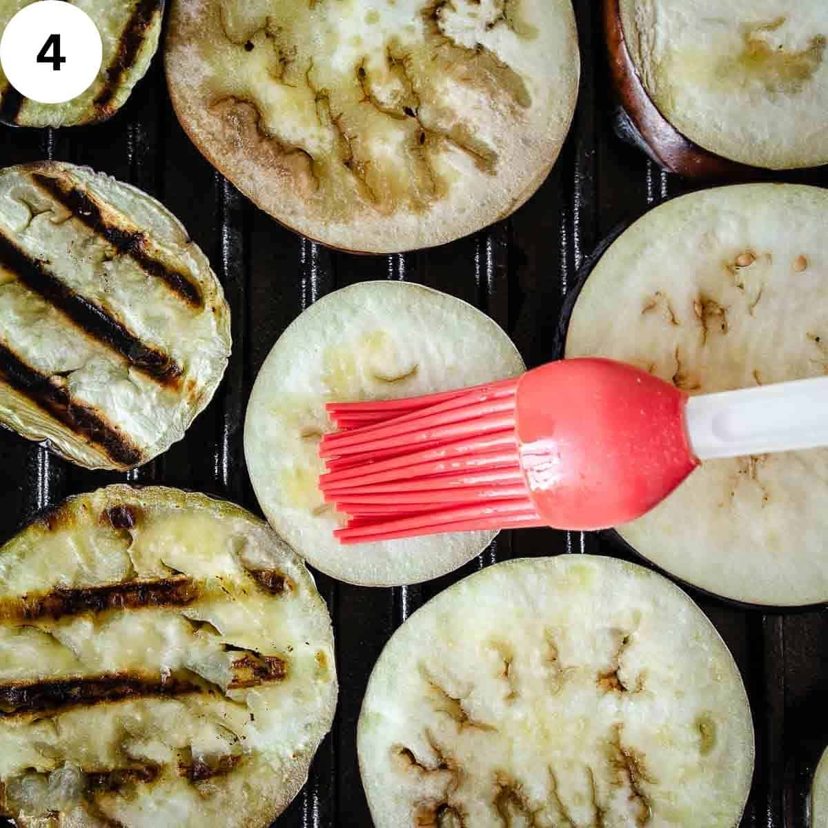 Brushing eggplant slices with oil.