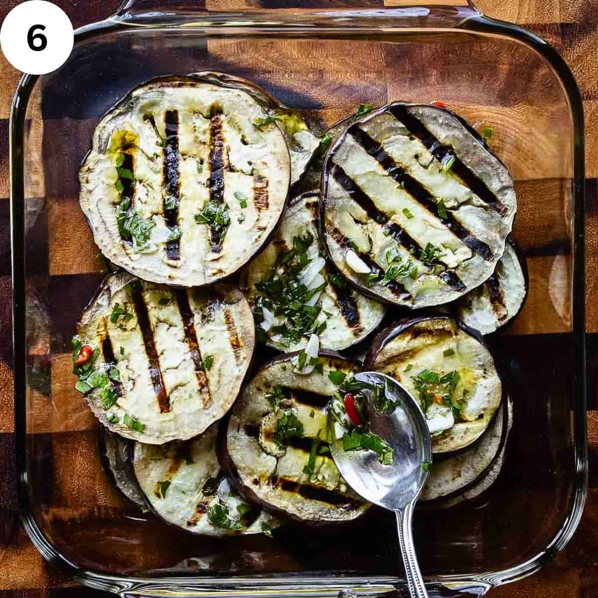 Spooning marinade over grilled eggplant slices.