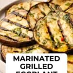 Grilled eggplant slices piled onto a round plate.