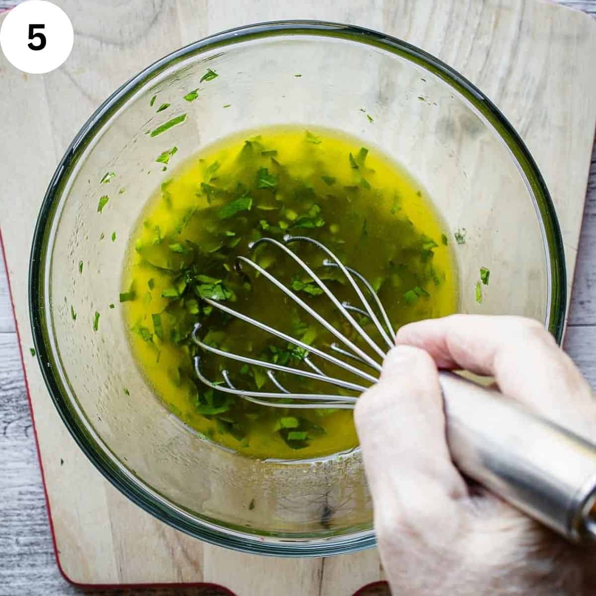 Whisking olive oil and herbs for a marinade.